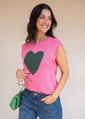 Pink acrylic knit vest with round neck and contrast green heart motif at the chest