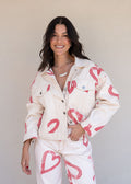 Ivory cotton drill denim jacket with all-over red heart print, front pockets, and barrel sleeves